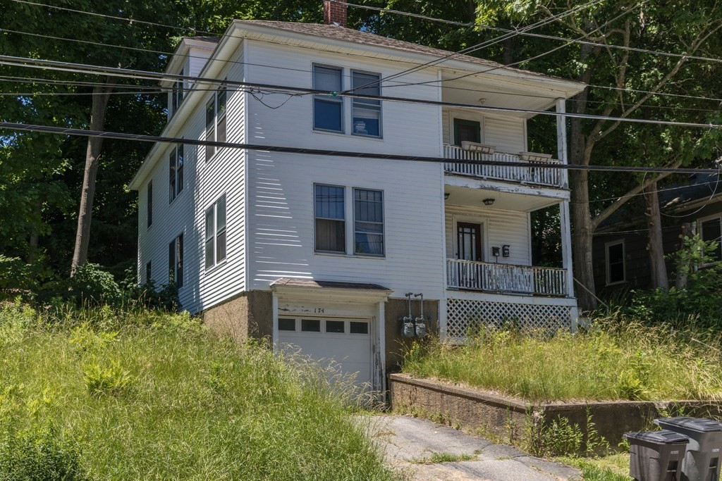 a view of house with yard and sitting area