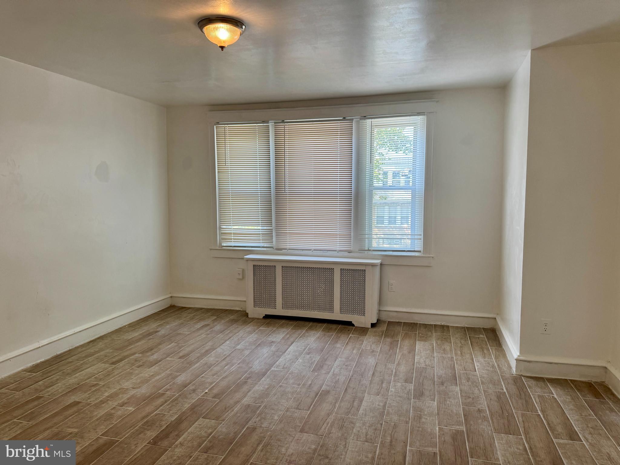 318 West Godfrey Avenue Philadelphia, PA 19120 - Photo 12 of 25 an empty room with wooden floor and windows