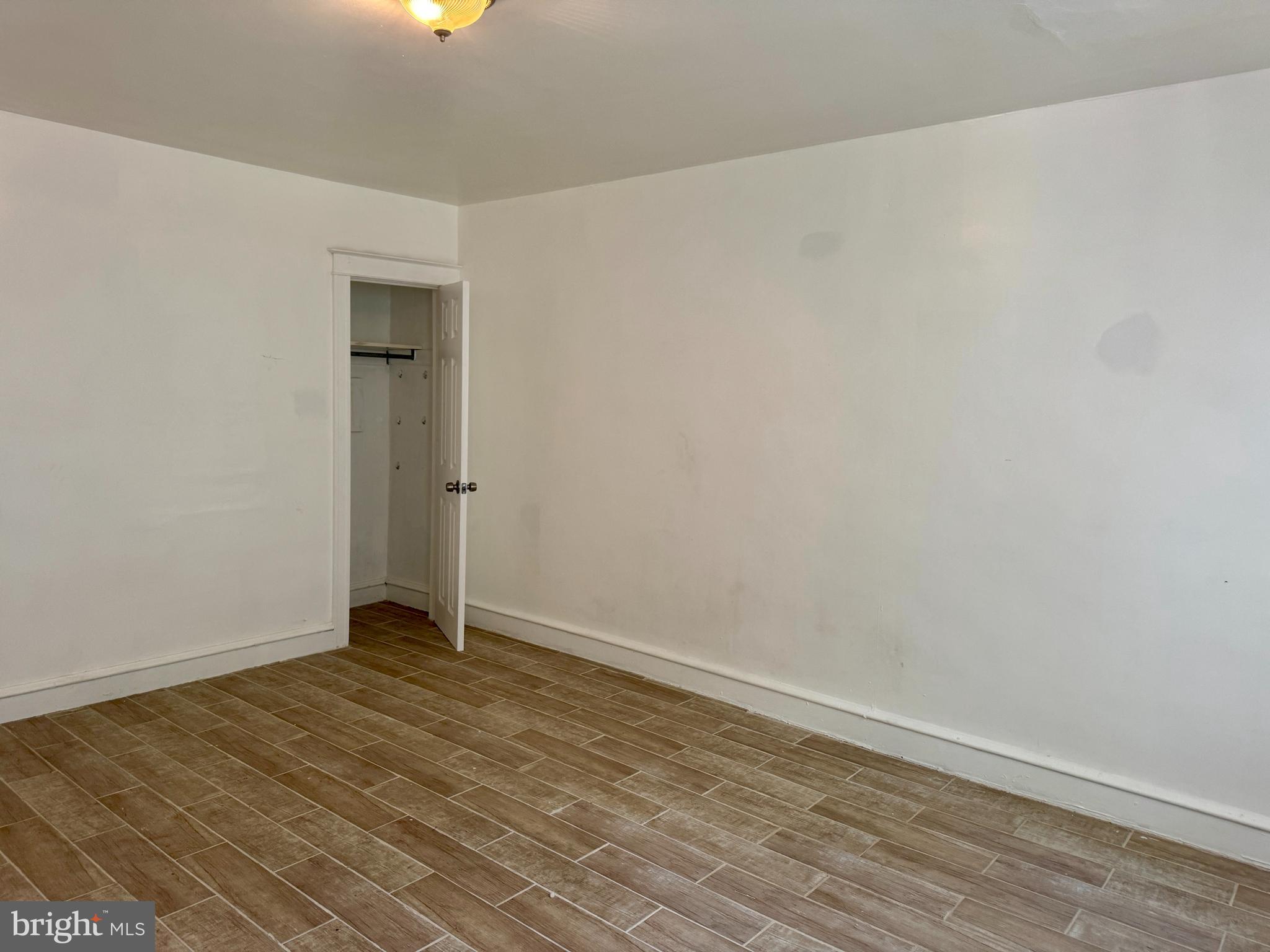 318 West Godfrey Avenue Philadelphia, PA 19120 - Photo 17 of 25 an empty room with wooden floor and windows