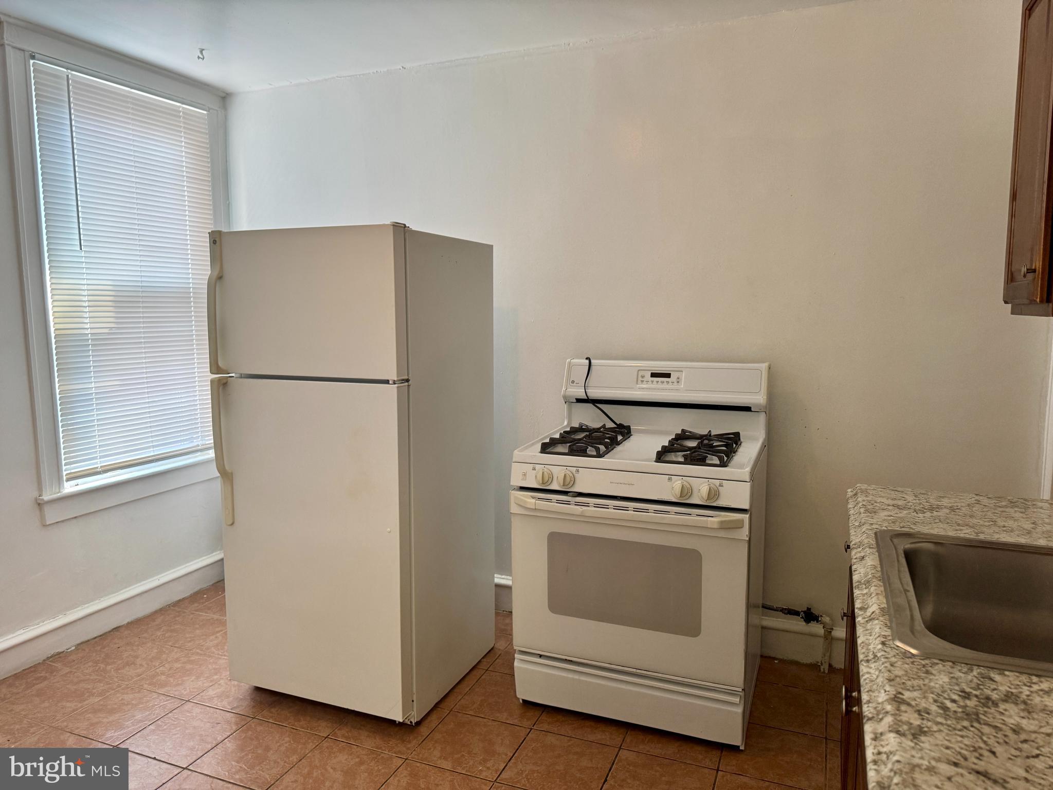 318 West Godfrey Avenue Philadelphia, PA 19120 - Photo 7 of 25 a white refrigerator freezer and a stove sitting inside of a kitchen