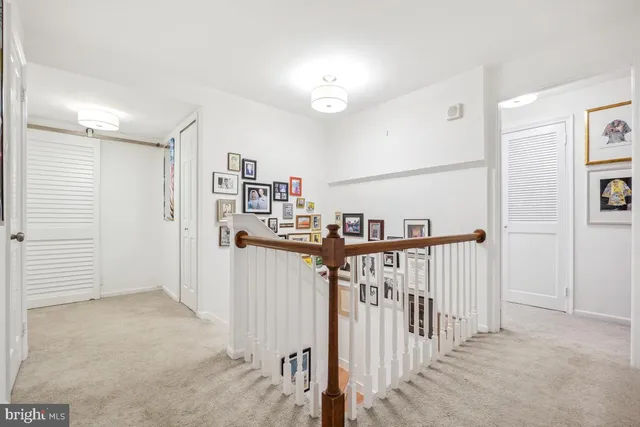 a view of a hallway with a livingroom and stairs
