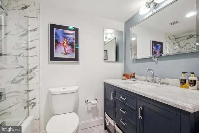 a bathroom with a granite countertop toilet sink and a mirror