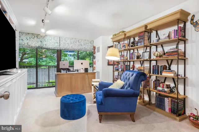 a living room with furniture a flat screen tv and a bookshelf