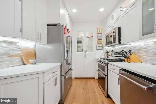 a kitchen with stainless steel appliances granite countertop a refrigerator and a stove top oven