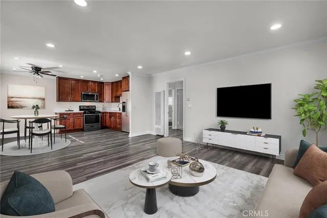a living room with furniture kitchen view and a flat screen tv