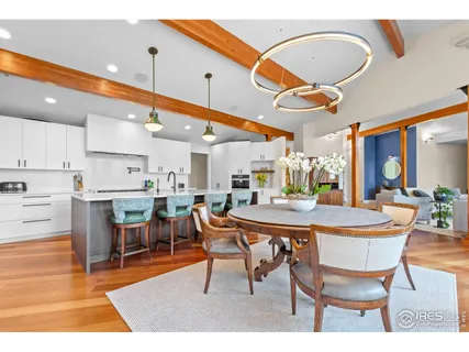 a dining hall with stainless steel appliances a dining table and chairs with wooden floor