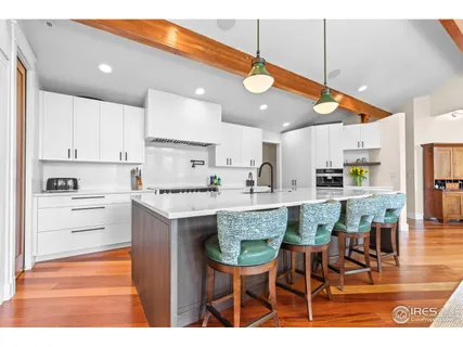 a kitchen with stainless steel appliances kitchen island granite countertop a table chairs and a refrigerator