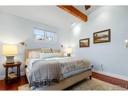 a bedroom with a bed and a painting on the wall