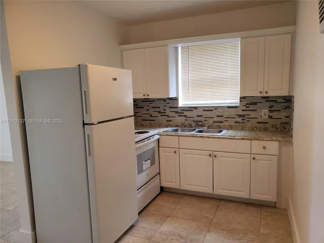 a white refrigerator freezer sitting inside of a kitchen