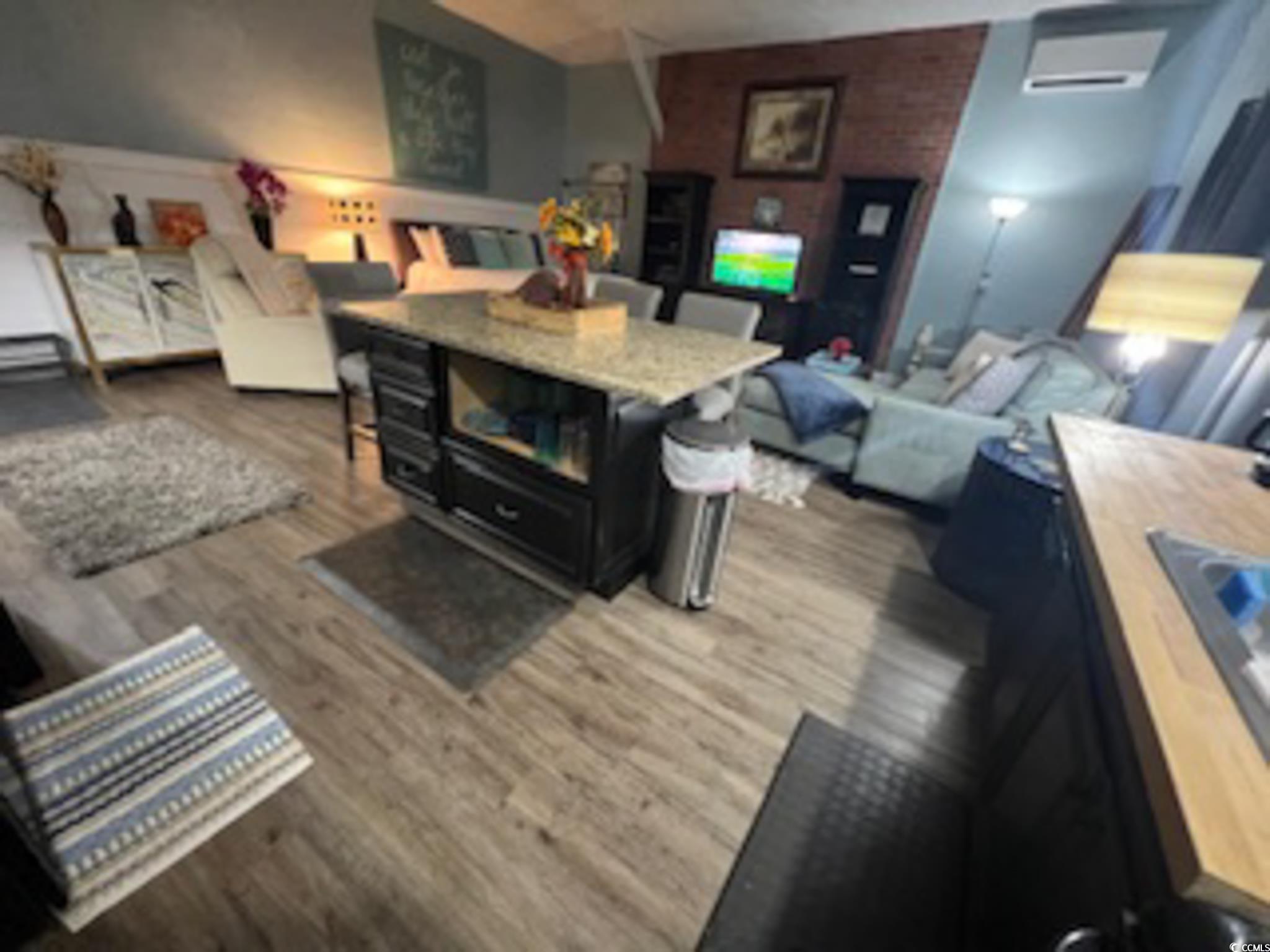 5588 Daybreak Road, Unit GUEST HOUSE Murrells Inlet, SC 29576 - Photo 5 of 18 Living area with dark wood finished floors and a wall unit AC