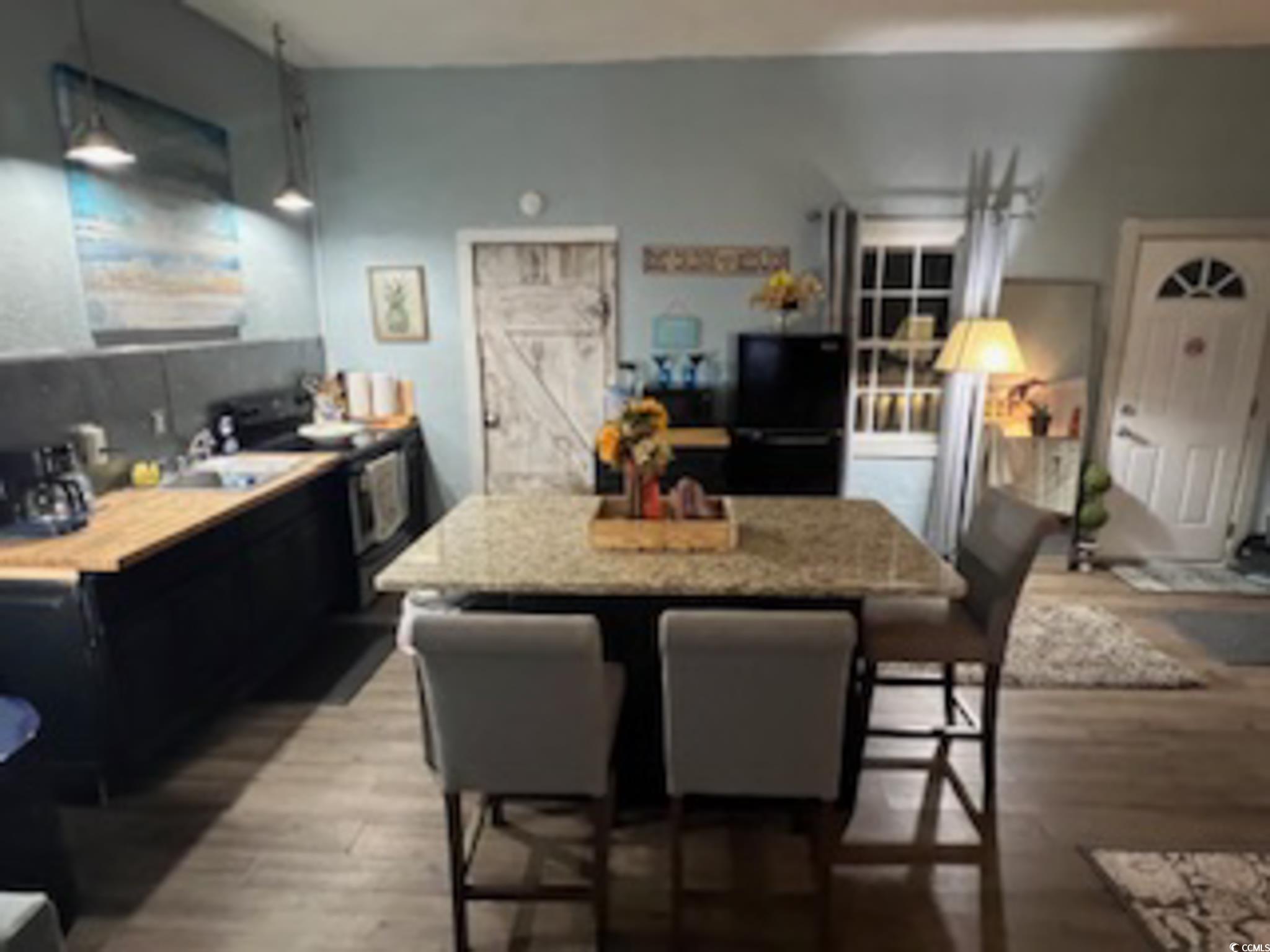 5588 Daybreak Road, Unit GUEST HOUSE Murrells Inlet, SC 29576 - Photo 9 of 18 Kitchen featuring a kitchen breakfast bar, stainless steel range with electric stovetop, dark wood-style floors, and a kitchen island