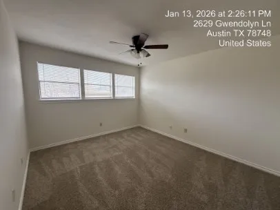 an empty room with windows and fan