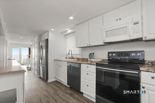 216 Broadway Milford, CT 06460 - Photo 6 of 18 a kitchen with stainless steel appliances granite countertop a stove a sink and a refrigerator