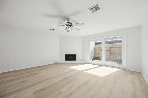 a view of an empty room with a fireplace and a window