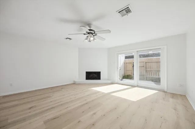 a view of an empty room with a fireplace and a window