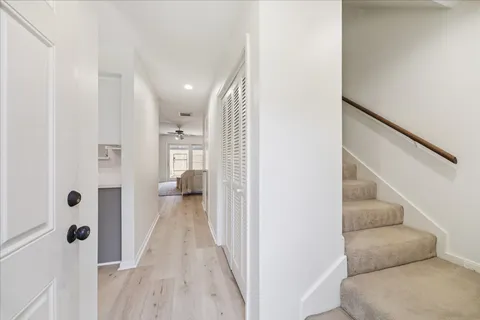 a view of a hallway with wooden floor and staircase