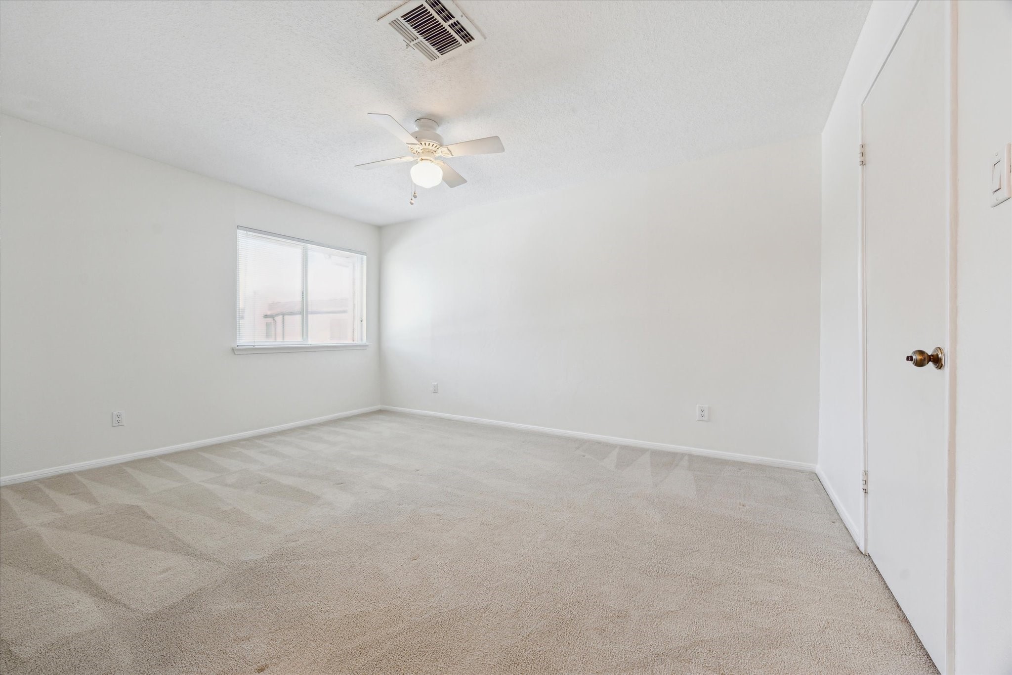 2515 Bering Drive, Unit 11 Houston, TX 77057 - Photo 16 of 26 an empty room with windows and fan