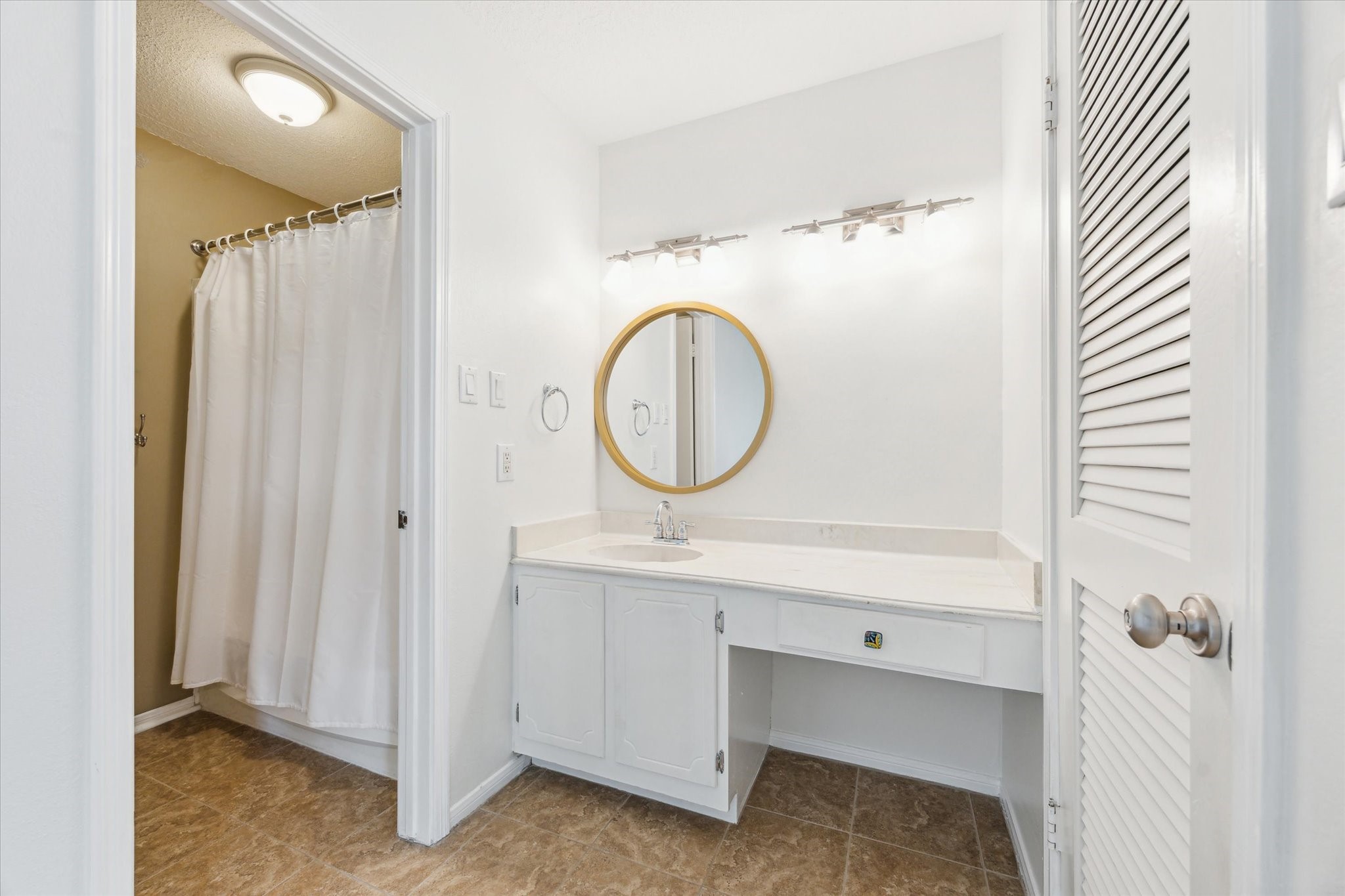2515 Bering Drive, Unit 11 Houston, TX 77057 - Photo 17 of 26 a bathroom with a sink a mirror and a shower
