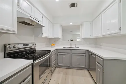 a kitchen with a sink stove and cabinets