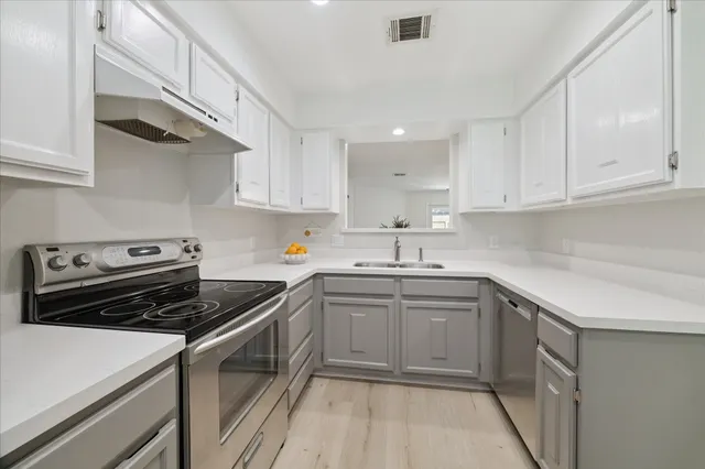 a kitchen with a sink stove and cabinets