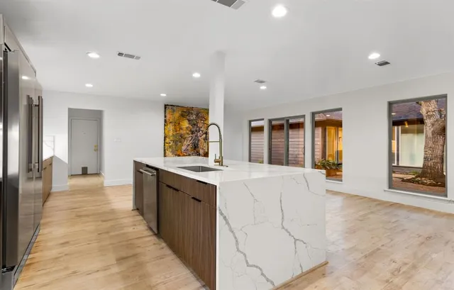 a large white kitchen with a large window