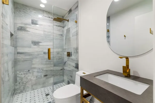 a bathroom with a sink a toilet and shower