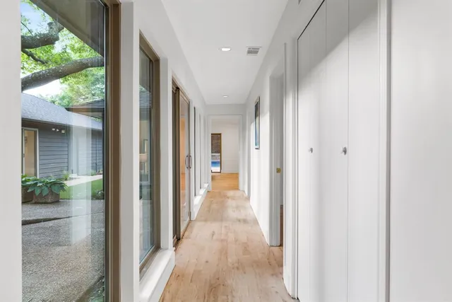 a view of a hallway with wooden floor and a living room