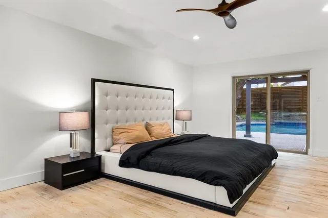 a bedroom with a bed window and a night stand