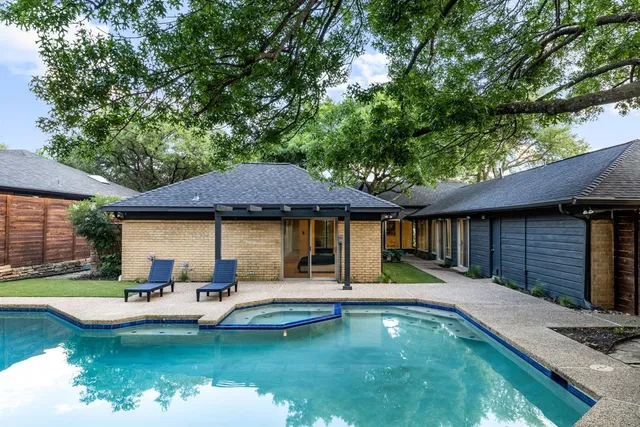 a house that has swimming pool in front of it