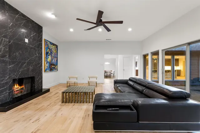 a living room with furniture fireplace and a large window
