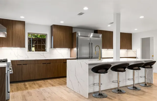 a kitchen with stainless steel appliances granite countertop a sink and a refrigerator
