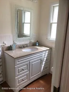 a bathroom with a granite countertop sink and a mirror