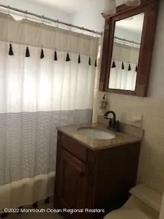 a bathroom with a granite countertop sink a mirror and shower