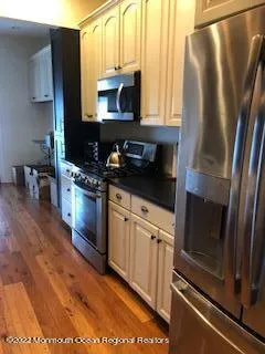 a kitchen with stainless steel appliances a refrigerator sink and microwave