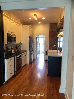 a kitchen with stainless steel appliances kitchen island granite countertop a stove a sink and a refrigerator