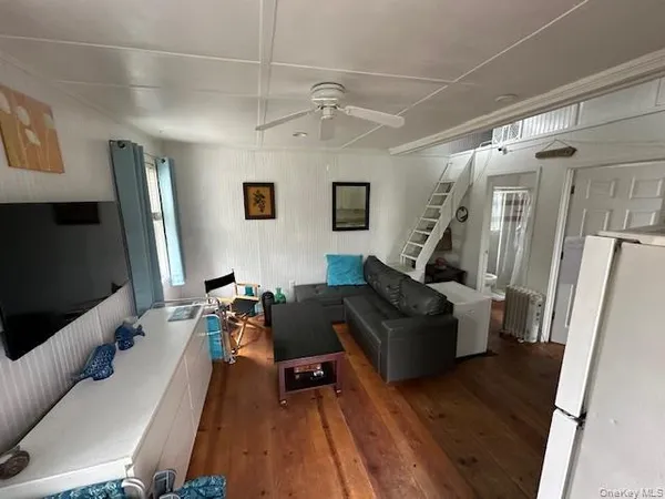 a living room with furniture and a refrigerator