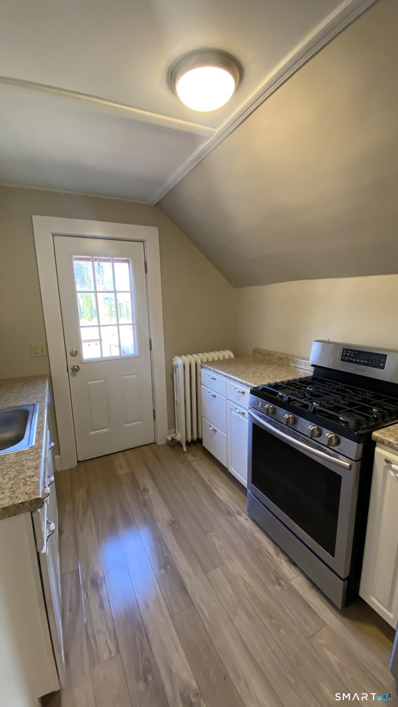 88 Belleview Avenue Torrington, CT 06790 - Photo 3 of 26 a view of a kitchen with a stove wooden floor and a window