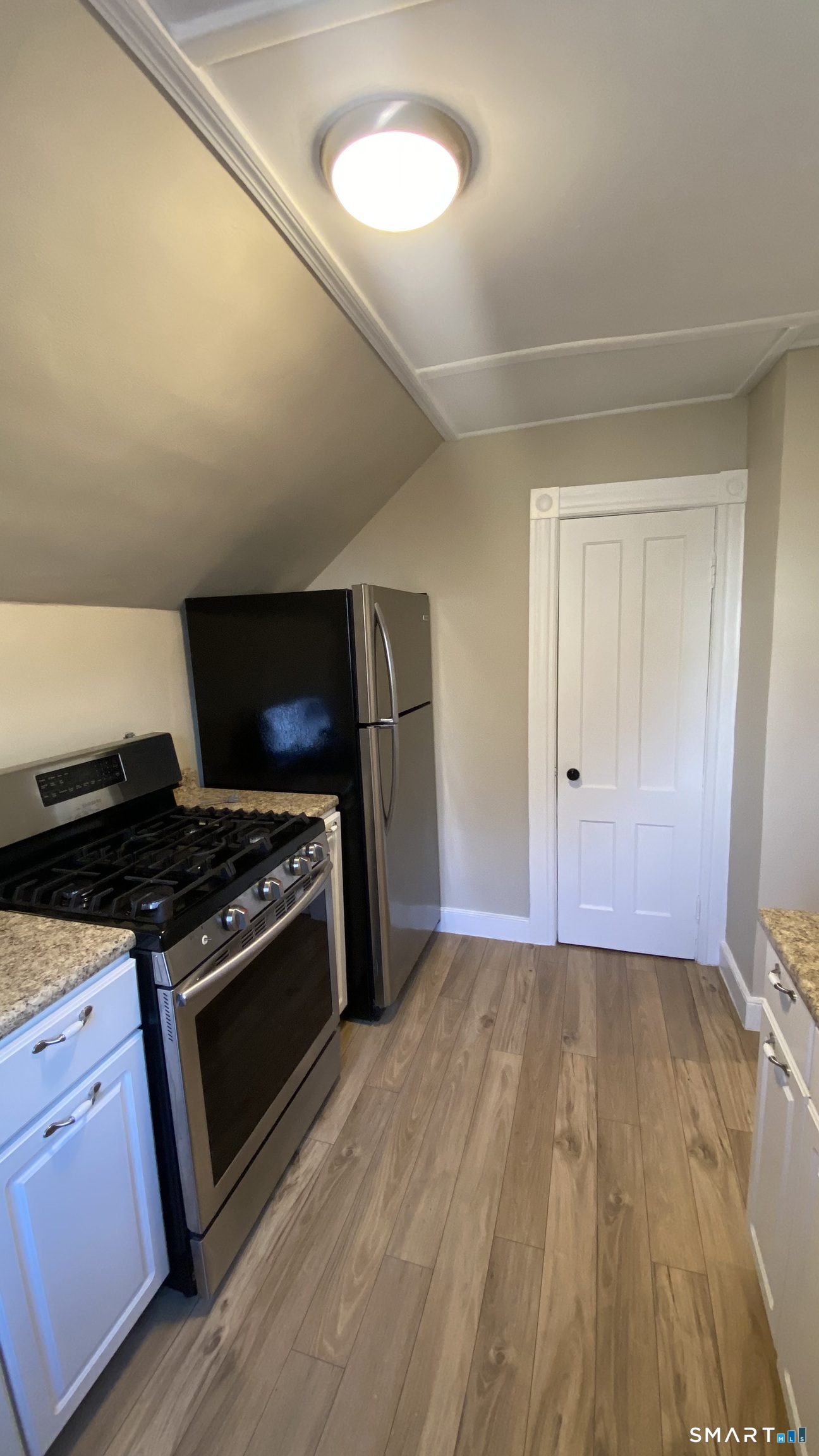 88 Belleview Avenue Torrington, CT 06790 - Photo 4 of 26 a kitchen with wooden floors and a stove top oven