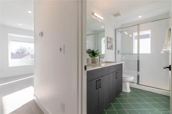 a bathroom with a double vanity sink toilet and a tub