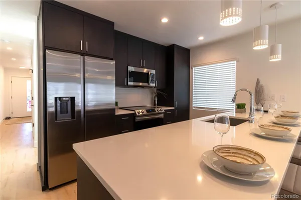 a kitchen with stainless steel appliances a sink stove and refrigerator