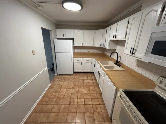 a kitchen with a sink a refrigerator and cabinets