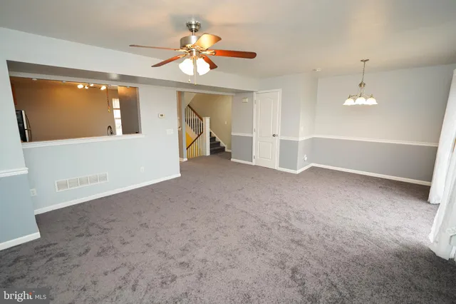 en empty room with windows and ceiling fan