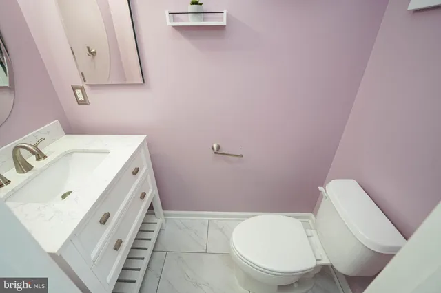 a bathroom with a sink a toilet and a mirror