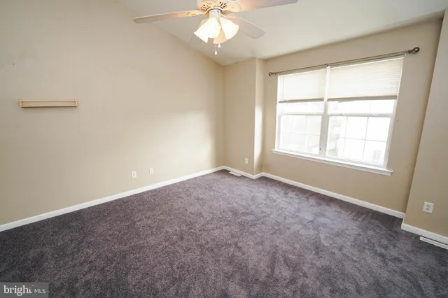 an empty room with closet and a chandelier fan