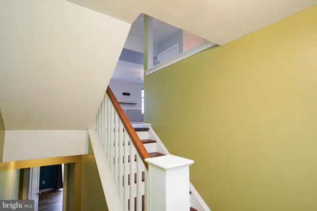 a view of a staircase with wooden floor and white walls