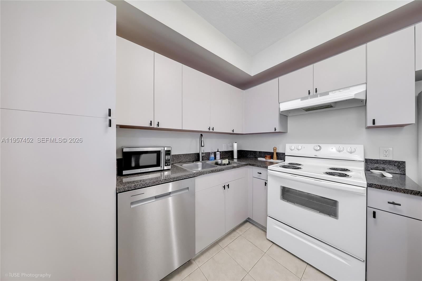 115 Southwest 11th Street, Unit 505 Miami, FL 33130 - Photo 6 of 21 a kitchen with cabinets appliances and a sink