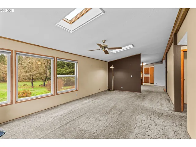 a view of a big room with windows and chandelier fan