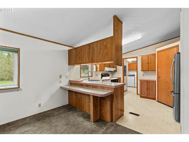 a kitchen with stainless steel appliances granite countertop a sink a stove and a refrigerator