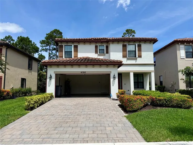 a front view of a house with a garden and plants
