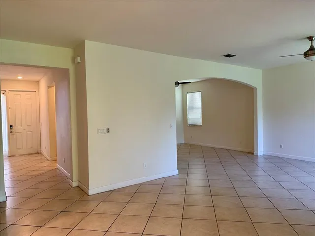 a view of a hallway with wooden floor and a bathroom